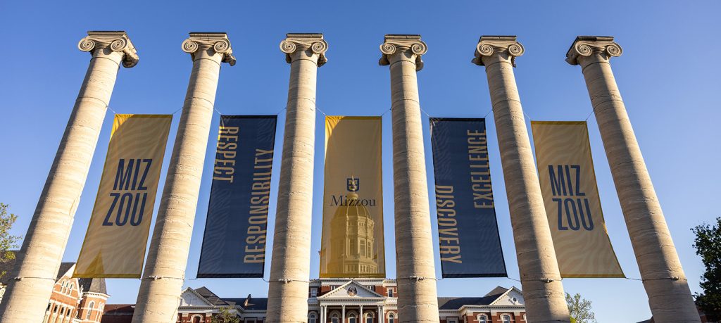 The Mizzou Columns on a sunny day, with Jesse Hall in the background.