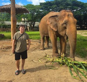 Arch Kimbriel posing for a photo next to an elephant.