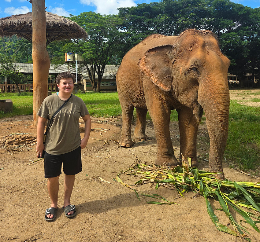 Arch Kimbriel posing for a photo next to an elephant.